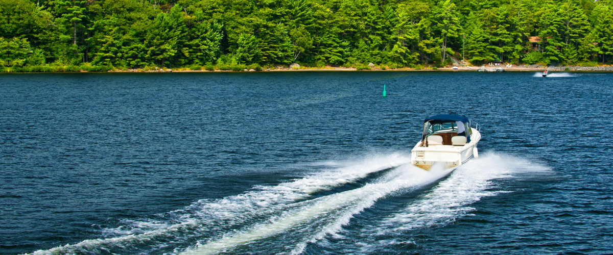 Boat driving on a lake on a summer day.