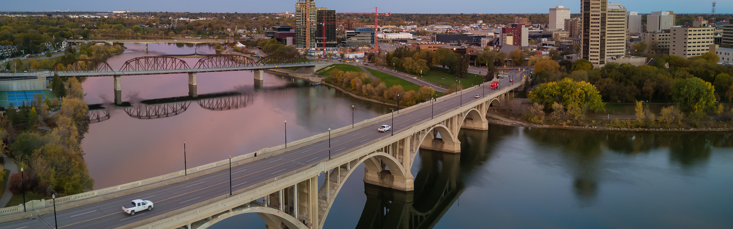 Saskatchewan landscape with vehicles crossing bridge.